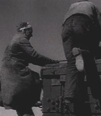 A hobo climbing up a box car.